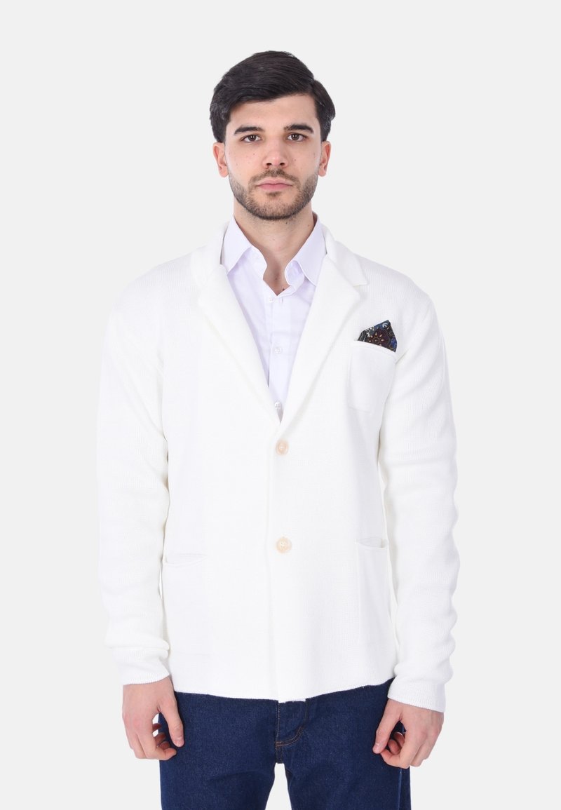 Blazer bianco a maglia con chiusura a un bottone, due tasche frontali e un fazzoletto decorativo. Tessuto testurizzato e vestibilità comoda.