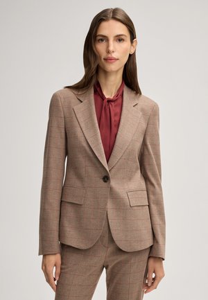 Karierte Blazer in Beige mit roten Akzenten, Ein-Knopf-Verschluss, Reverskragen und zwei Fronttaschen, kombiniert mit einer bordeauxfarbenen Bluse.