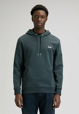 Ciemnozielona bluza z kapturem wykonana z miękkiego materiału, z przednią kieszenią typu kangur, kapturem ze sznurkiem oraz białym logo na piersi.