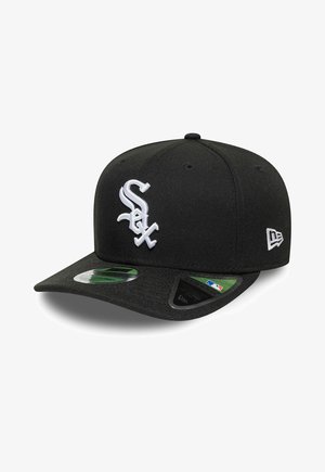 Black baseball cap with white Chicago White Sox logo on front and New Era logo on side, flat brim with MLB stickers.