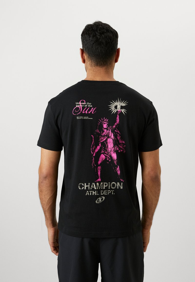 Schwarzes Baumwoll-T-Shirt mit einem großen pinken Grafik eines Statuen, die eine Fackel hält, mit dem Text "Entfessle die Kraft der Sonne" und "CHAMPION ATHL. DEPT." in Silber.