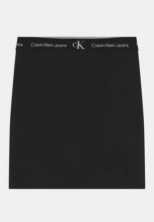 Czarna mini spódnica z elastycznym pasem, na którym powtarzają się białe napisy „Calvin Klein Jeans” i logo „cK”.