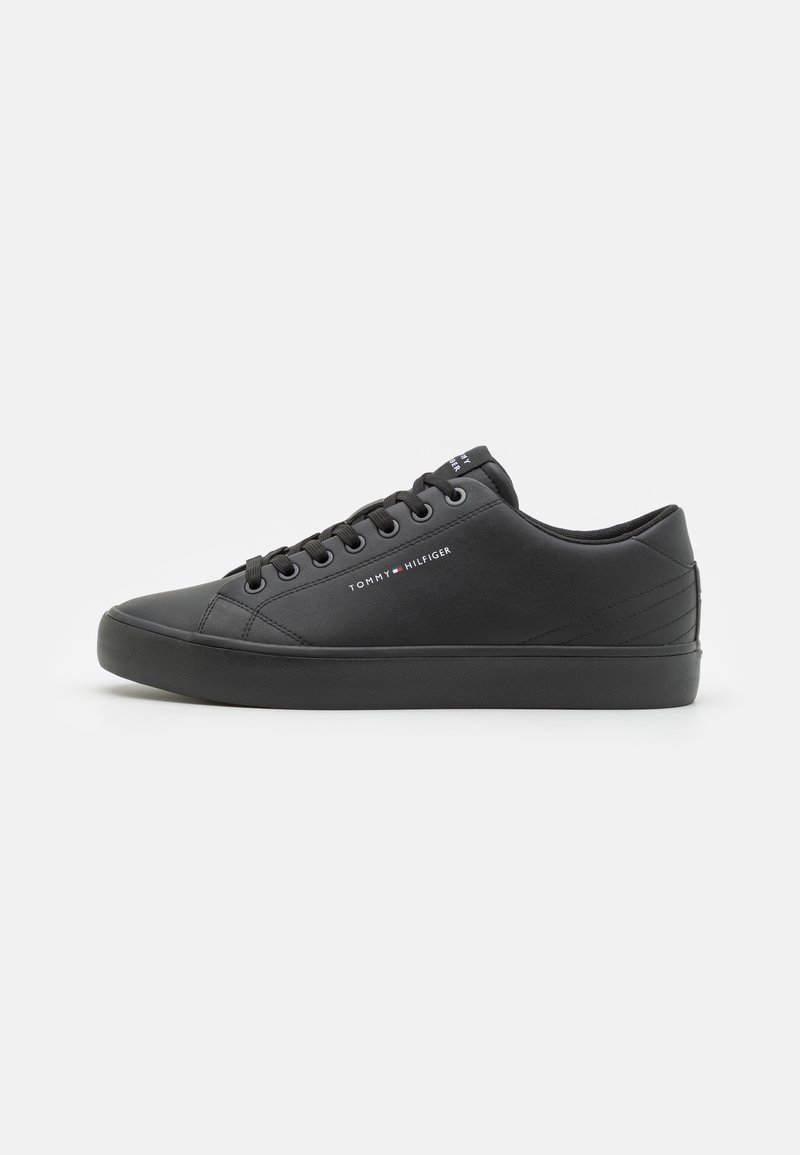 Czarne sportowe buty z gładką, syntetyczną cholewką, okrągłym noskiem, płaską gumową podeszwą i tonalnym szyciem. Posiadają logo na boku oraz sznurowane zapięcie.