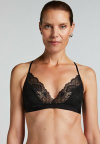 Zwarte kanten bralette met een driehoekig design, verfijnde bloemmotieven, verstelbare bandjes en een gladde onderband.