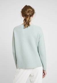 Helles blaues Strickpullover mit lockerer Passform, geripptem Muster und langen Ärmeln. Einfaches Design mit Rundhalsausschnitt.