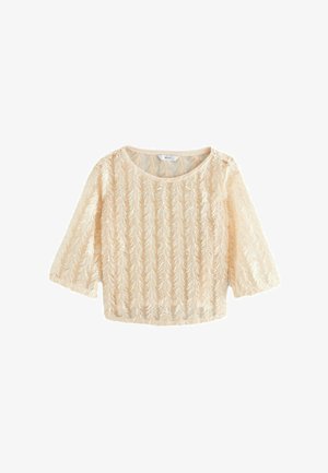 Beige skrajšan top iz prosojne tkanine z vezenimi navpičnimi vzorci listov. Ima tri četrtinske rokave in okrogel ovratnik.