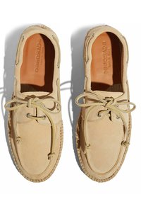 Zapatos de ante beige con punta redondeada, diseño con cordones, detalles cosidos y suela texturizada. Forro interior suave visible.