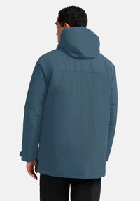 Heren blauwe waterdichte jas met een capuchon, met een soepele textuur, volledige rugbedekking en verstelbare manchetten.