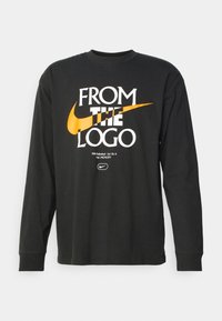 Black long-sleeve t-shirt made of cotton, featuring white and orange printed text and the Nike logo across the front.