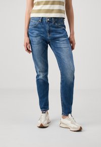 Ljusblå denimjeans med hög midja och tapered passform, med lätt slitage och klassisk femfickdesign.