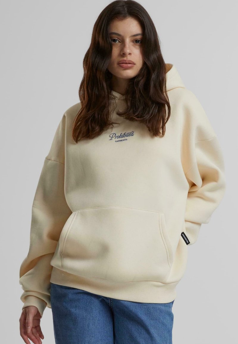 Hanorac de culoare crem, cu buzunar frontal și manșete ribbate. Are brodat "Îmbrăcăminte Interzisă" în albastru închis. Design casual.