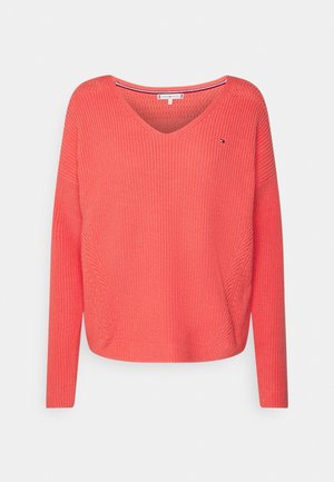 Koraalroze gebreide trui met lange mouwen en een brede V-hals, met een klein logo op de linker bovenborst.