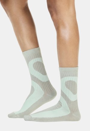 Sive gležnjače svijetlo sive boje s apstraktnim uzorkom u boji metvice. Izrađene od teksturiranog pletiva s rebrastim elastikama za čvrsto prianjanje.