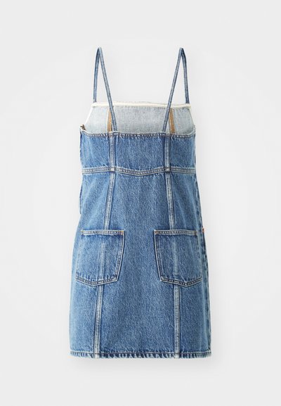 Vestido de denim con tirantes finos, degradado de azul claro a oscuro, dos bolsillos delanteros y detalles de costura visibles. Forma clásica en A.