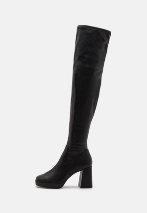 Bottes noires au-dessus du genou en cuir lisse avec un talon épais, dotées d'un bout arrondi et d'une silhouette élégante.