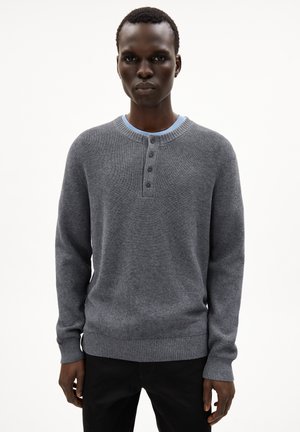 Grauer gestrickter Pullover mit Rundhalsausschnitt, versehen mit einer Knopfleiste mit drei Knöpfen sowie elastischen Bündchen und Saum. Leichte Textur.