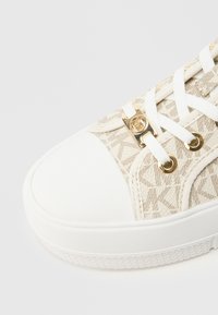 Μπεζ αθλητικό παπούτσι με κορδόνια, με επάνω μέρος από υφαντό ύφασμα με σχέδιο, λευκή λαστιχένια μύτη και σόλα. Διαθέτει εξαρτήματα σε χρυσό τόνο και λευκά κορδόνια.