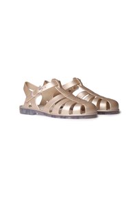 Beige plastic sandals with open-toe design, horizontal and vertical cutouts, ankle strap, and transparent soles. Smooth texture and lightweight.