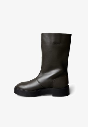 Eleganter brauner Leder-Stiefel bis zum Knöchel mit glatter Oberfläche, abgerundetem Zehenbereich und dicker schwarzer Gummisohle; minimale sichtbare Nähte.
