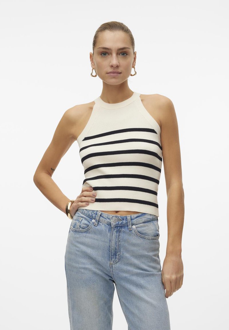 Striped top s halter krkem v krémové a námořnické modré barvě, s ribbovanou texturou. V kombinaci se světle modrými džíny s high-waisted.