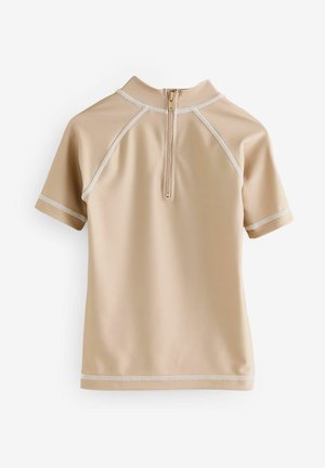 Kurzarm-Rashguard in Beige, aus glattem synthetischen Material, mit einem halben Reißverschluss und kontrastierender weißer Naht.