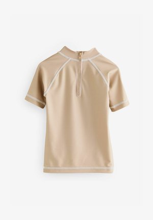 Krátky rukáv rash guard v béžovej farbe, vyrobený z hladkého syntetického materiálu, s polovičným zipsom a kontrastným bielym šitím.