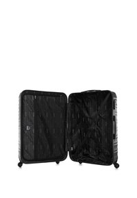 Valise rigide noire avec un design à fente, dotée d'un intérieur en tissu, de sangles croisées, d'un compartiment zippé et de quatre roues pour faciliter le déplacement.
