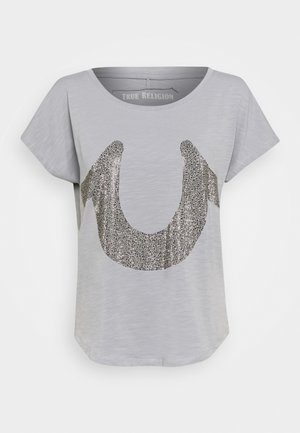 Grijs T-shirt met korte mouwen gemaakt van zachte stof, met een groot logo in metallic zilverglitter in het midden. Gladde textuur, losvallende pasvorm.