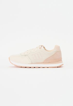 Zapatilla deportiva beige con parte superior de malla, detalles de ante y suela de goma rosa. Diseñada para la comodidad con un cierre de cordones.