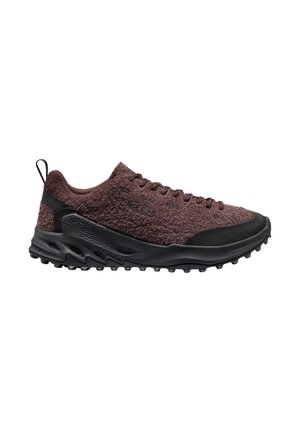 Sneaker marrone a taglio basso con texture, suola nera e punta rinforzata, chiusura con lacci e linguetta sul tallone, progettata per uso esterno.