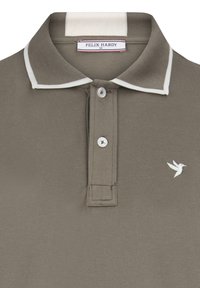 Polo de color verde oliva con un tejido texturizado, forro de collar blanco, tapeta de dos botones y un pequeño logo de colibrí blanco.