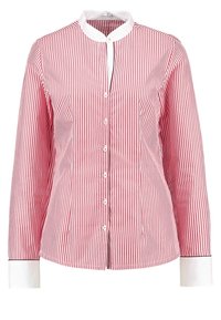 Camisa abotonada de rayas verticales rojas y blancas, con cuello mao, mangas largas y puños blancos en contraste. Tejido de algodón suave.