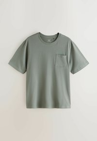 T-shirt en coton vert sauge à manches courtes avec un col rond et une poche sur le côté gauche de la poitrine, présenté sur un fond clair uni.