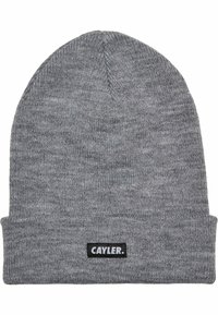 Grå strikket lue med brett og et svart merke med påskriften "CAYLER." Jevn tekstur med tett vevd design.