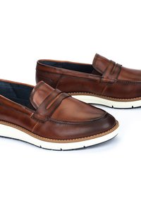 Bruine leren loafers met een gladde afwerking, voorzien van een bandaccent en gevoerde zolen. De buitenzool bevat witte en zwarte details.