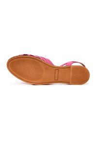 Sandale pour femme rose avec une semelle plate en caoutchouc marron, zones antidérapantes texturées et design à bout ouvert, vue par le dessous.