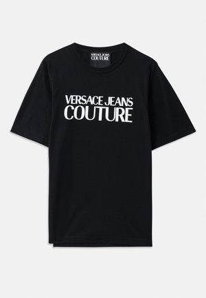 Crna pamučna majica s kratkim rukavima s velikim bijelim natpisom "VERSACE JEANS COUTURE" sprijeda. Klasični dizajn s okruglim izrezom.