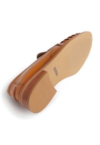Brown leather shoe with a smooth finish, featuring a low heel and textured rubber sole. Notable for its horizontal cutouts along the sides.