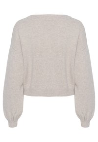 Ljus beige kort tröja med en mjuk, texturerad stickning. Har nedhasade axlar och puffärm, avslutad vid midjan med ribbat detaljer.