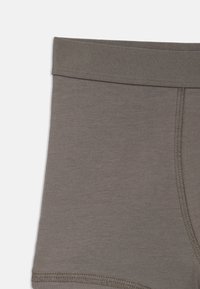 Bóxer de algodón gris con cinturilla elástica, que presenta costuras planas y una textura suave. El diseño es simple y ceñido al cuerpo.