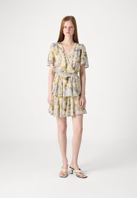 Rochie florală de culoare galben pal, cu modele verzi și albastre, tiv ondulat, mâneci scurte tip fluture și detaliu cu cordon la talie.