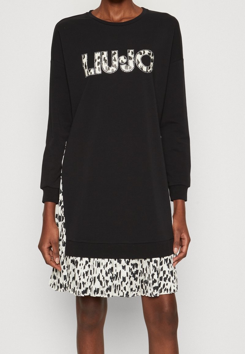 Schwarzes Sweatshirtkleid mit einem Stufenrock im Leopardenmuster. Das Oberteil hat lange Ärmel und einen runden Halsausschnitt mit „LIU-JO“-Logo-Details.