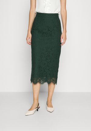 Roheline pitsiline pliiatsiseelik lillemustriga, lainelise ääre ja tekstuuriga viimistlusega, millele on sobitatud kreemjad terava ninaga kingad.