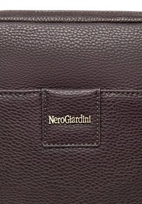 Portafoglio in pelle marrone texturizzata con cucitura a vista. Presenta un logo "NeroGiardini" dorato su una targhetta rettangolare di pelle.