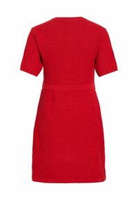 Robe rouge en tricot à manches courtes, avec une taille cintrée et un motif texturé. Ourlet lisse et ceinture assortie mettent en valeur la silhouette.