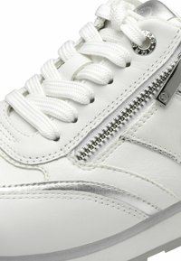 Sneaker in pelle bianca con dettagli argentati, una cerniera laterale e superficie testurizzata. Presenta lacci bianchi e una suola sagomata.