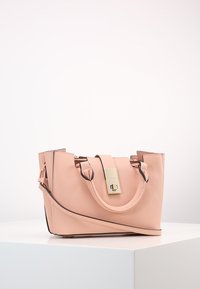 Różowa, syntetyczna torebka o strukturalnym kształcie, z złotym zapięciem, krótkimi uchwytami i kontrastującym czarnym wykończeniem wzdłuż brzegów.