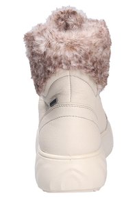 Bottine en cuir blanc avec un revers en fausse fourrure beige. Texture lisse, design arrondi et détails de couture minimalistes sur les côtés.