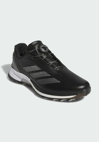 Black athletic shoe with white sole, featuring a BOA dial lacing system and three gray Adidas stripes on the side.