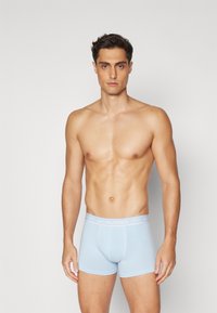 Hellblaue Boxershorts mit elastischem Bund, beschriftet "JACK & JONES." Glatte Textur, enganliegendes Design, doppelt genähte Nähte.
